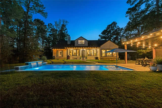 a view of pool with umbrella and trees