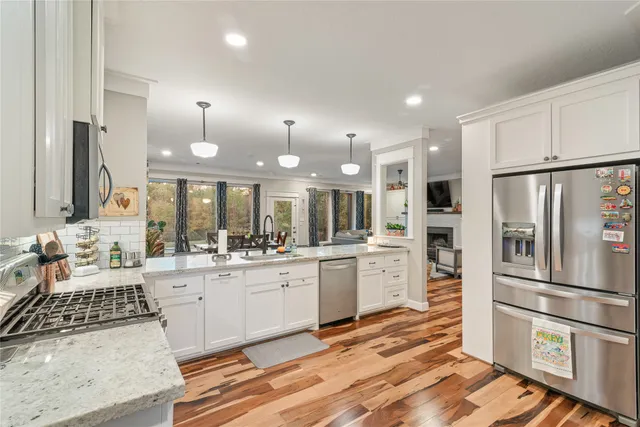 a large kitchen with stainless steel appliances kitchen island granite countertop a refrigerator and stove