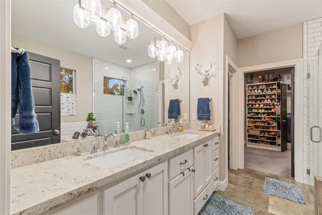 a bathroom with a granite countertop sink a large mirror and a shower