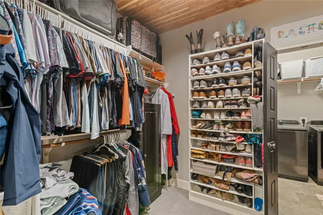 a view of walk in closet with clothes and shoes
