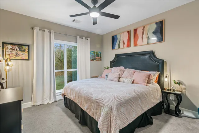 a bedroom with a large bed and a chandelier