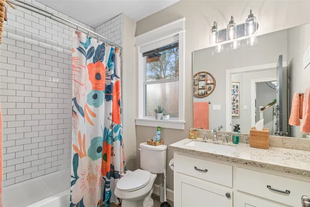 a bathroom with a sink a toilet and shower curtain