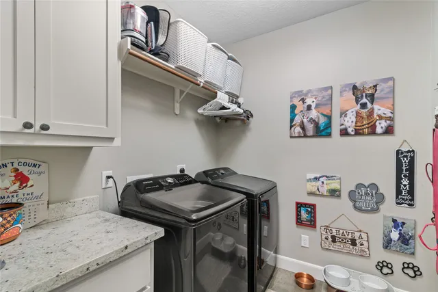 a utility room with lots of clutter and cabinets