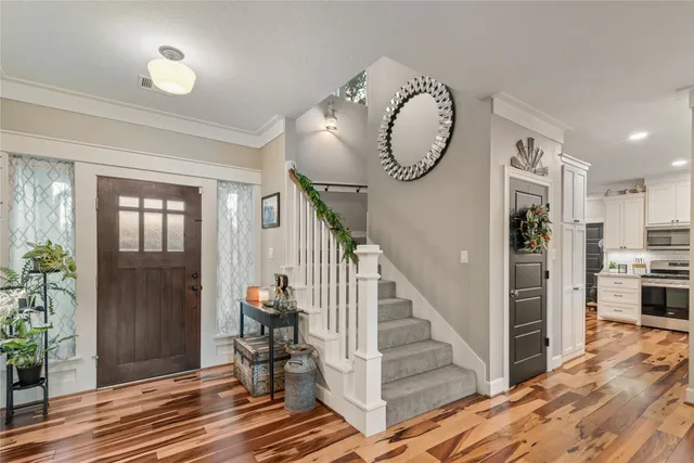 a view of a hallway with wooden floor and entryway