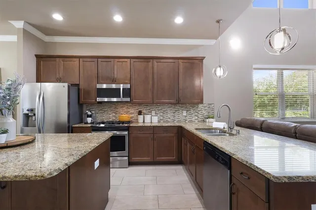 a kitchen with stainless steel appliances granite countertop a sink counter space cabinets and a large window