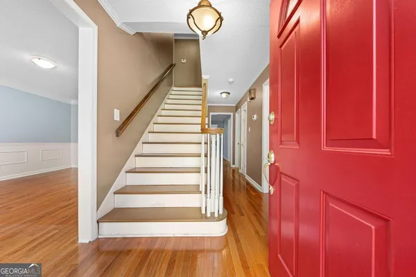 a view of staircase with wooden floor and fan