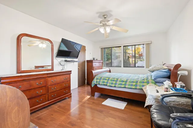 a bedroom with a bed and a mirror on the dresser