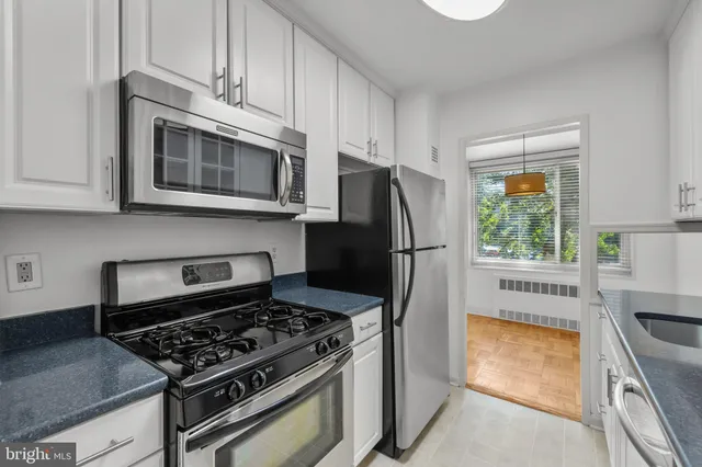 a kitchen with stainless steel appliances granite countertop a stove a refrigerator and a microwave