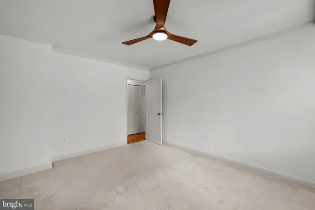 a view of an empty room with a chandelier fan