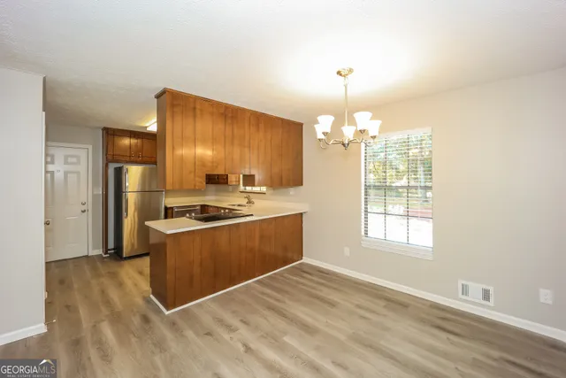 a kitchen with granite countertop a stove cabinets and wooden floor