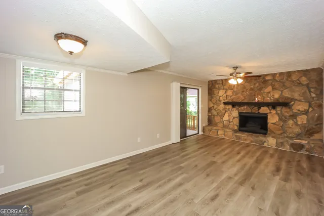 an empty room with windows and fireplace