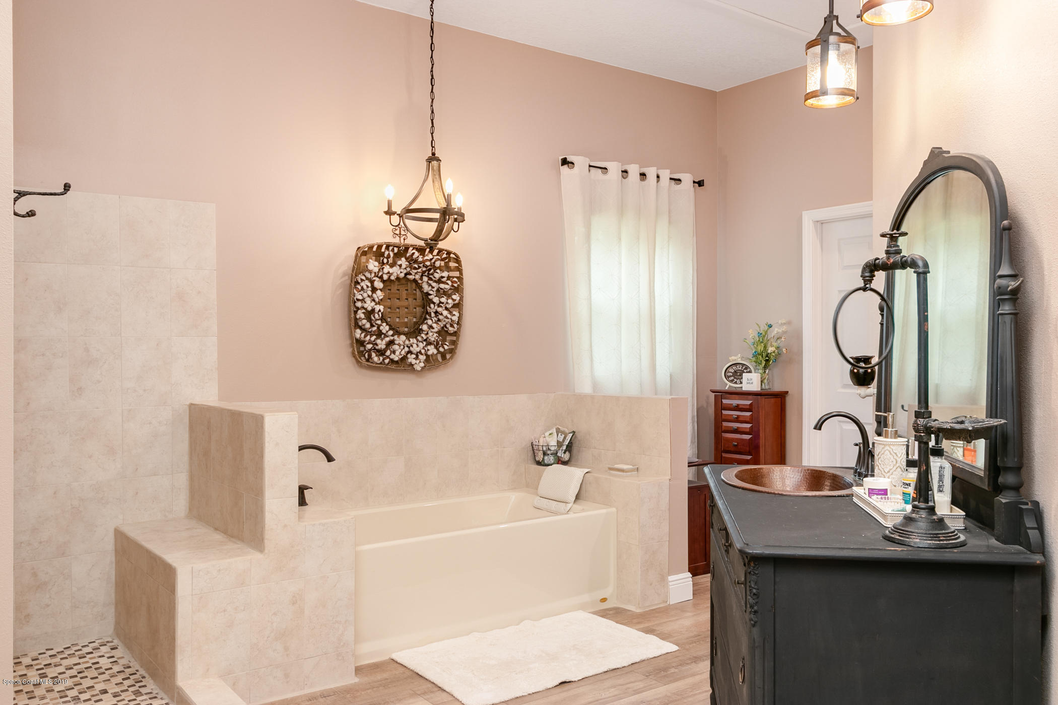 1760 Corey Road Malabar, FL 32950 - Photo 17 of 39 a bathroom with a sink a mirror a bathtub and shower