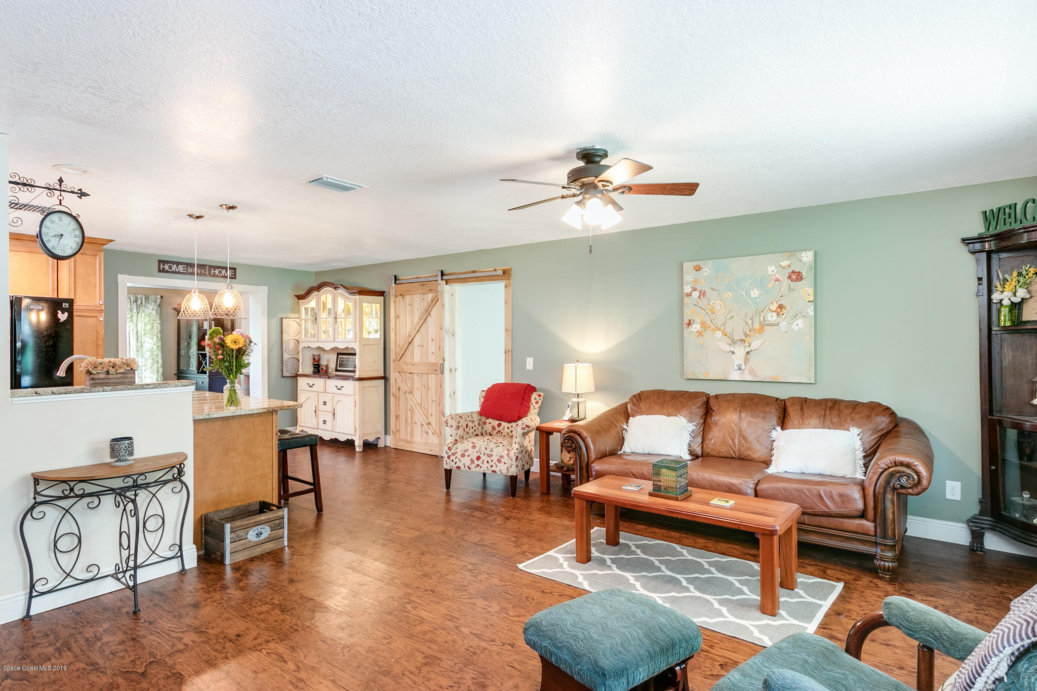 1760 Corey Road Malabar, FL 32950 - Photo 6 of 39 a living room with furniture and a chandelier