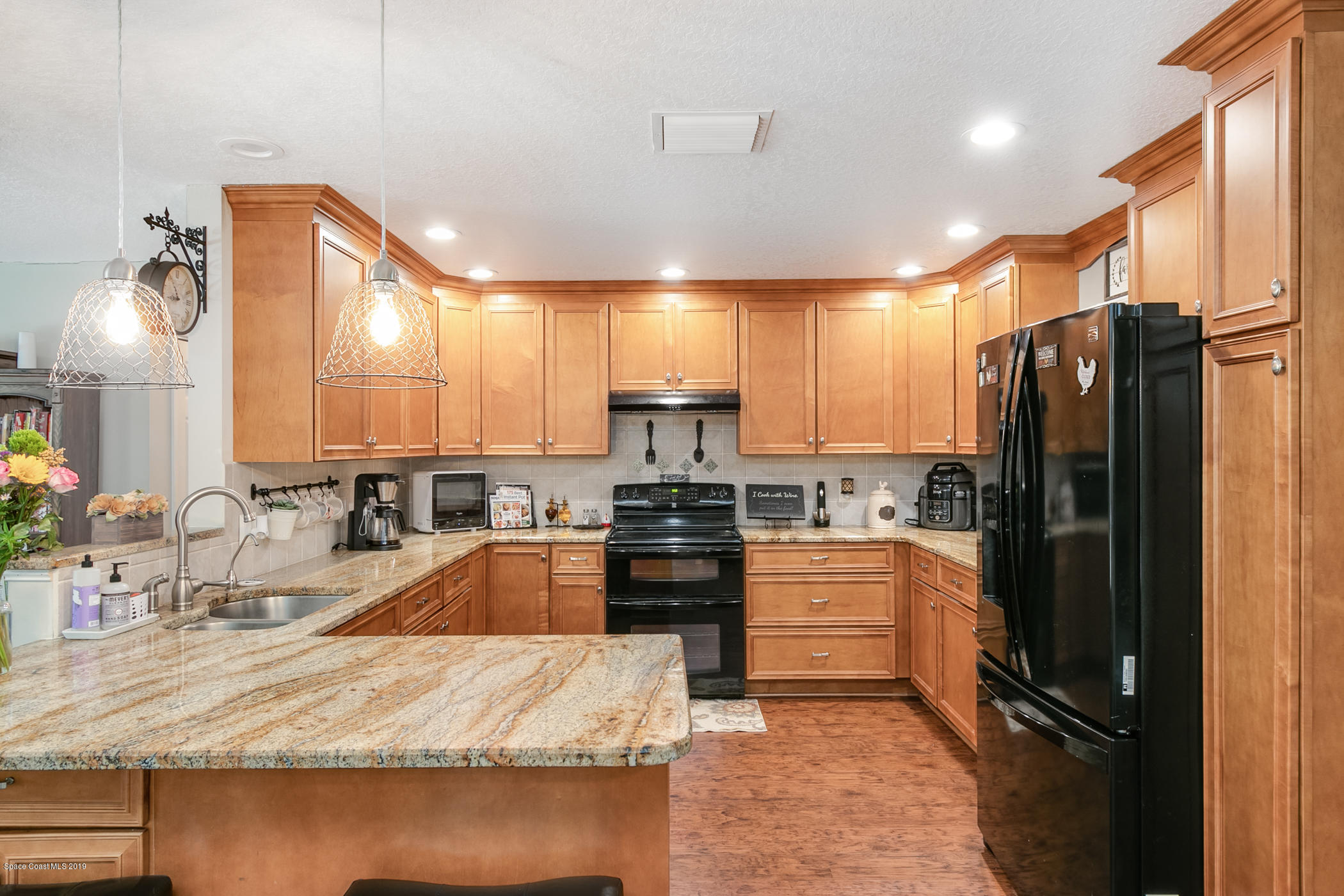 1760 Corey Road Malabar, FL 32950 - Photo 8 of 39 a kitchen with granite countertop a refrigerator stove and sink
