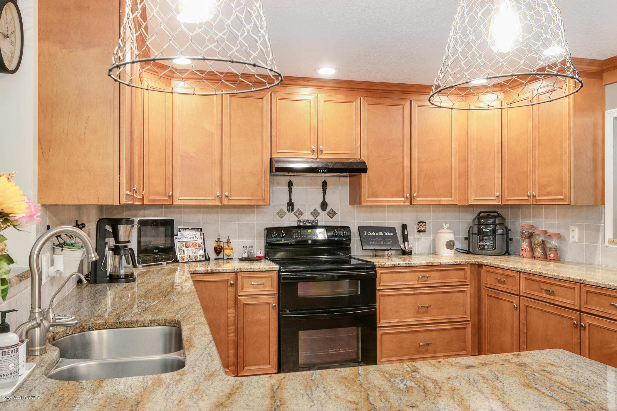 1760 Corey Road Malabar, FL 32950 - Photo 9 of 39 a kitchen with stainless steel appliances granite countertop a sink a stove and a refrigerator