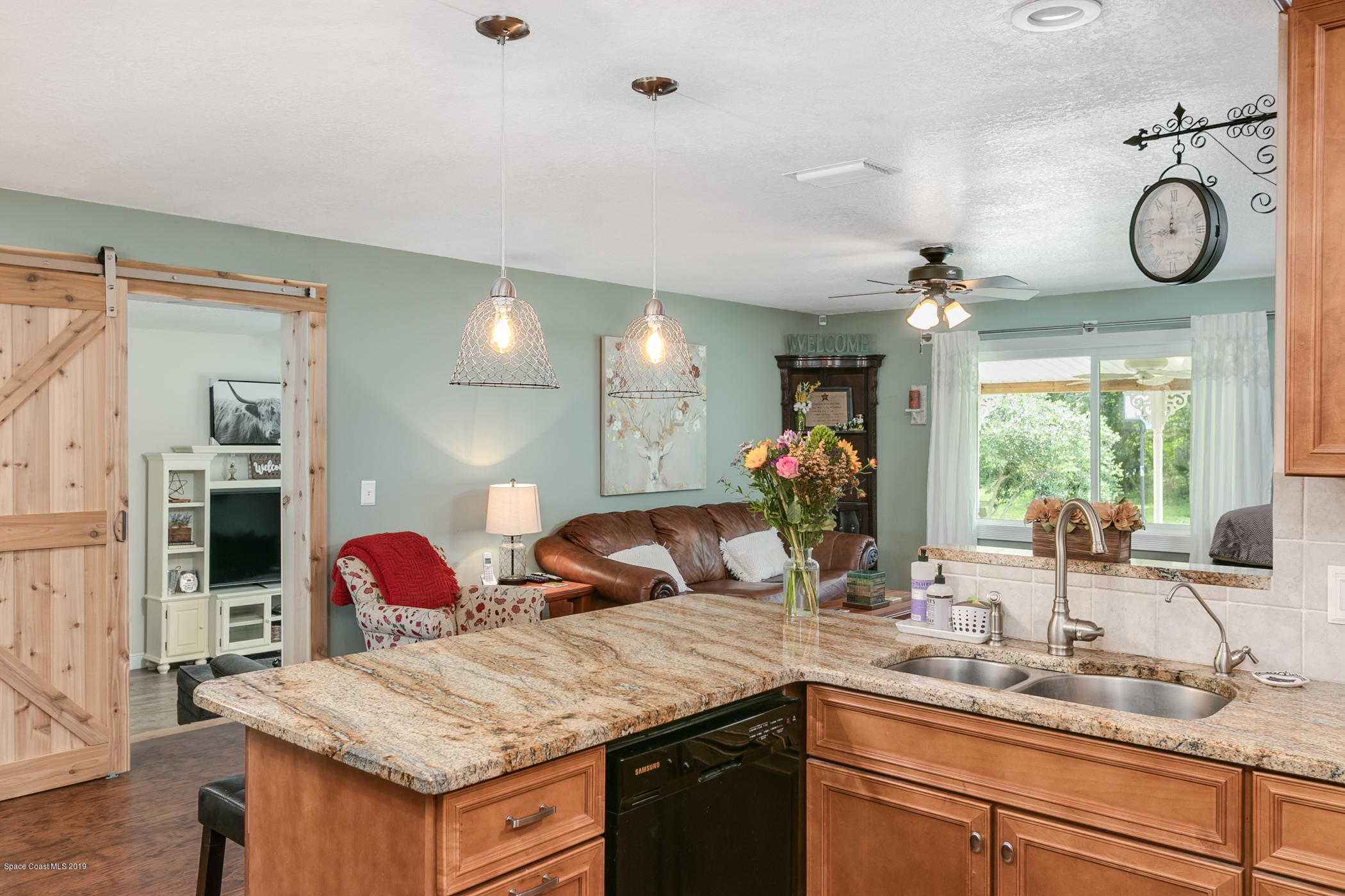 1760 Corey Road Malabar, FL 32950 - Photo 10 of 39 a view of a kitchen island a sink and living room view