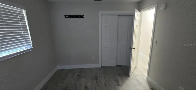 a view of a small space with wooden floor and a window