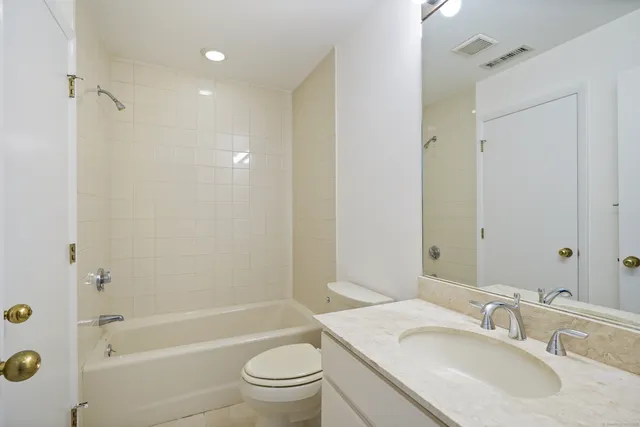 a bathroom with a granite countertop sink toilet and shower