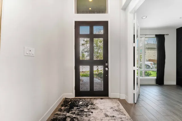 a view of a hallway with wooden floor and a window