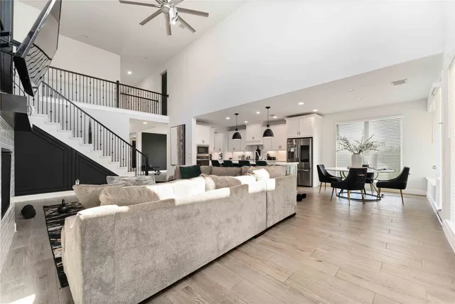 a living room with furniture kitchen view and a chandelier