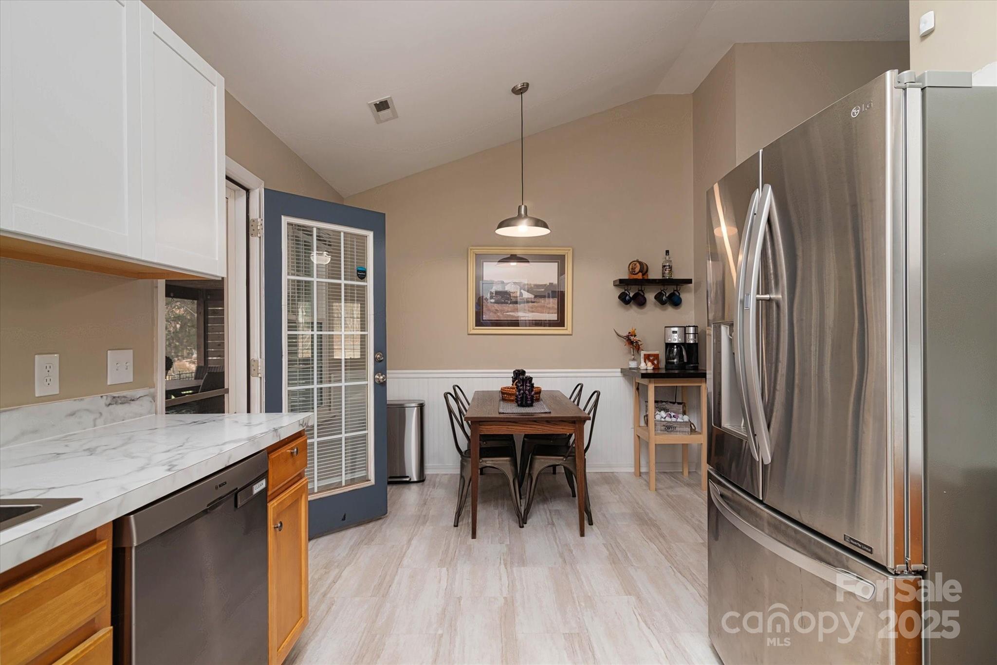 1216 Stevens Road Monroe, NC 28110 - Photo 11 of 40 a kitchen with stainless steel appliances granite countertop a refrigerator a sink dishwasher a stove and a dining table with wooden floor
