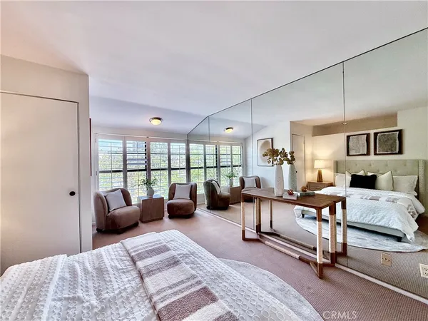 a bedroom with furniture and large windows