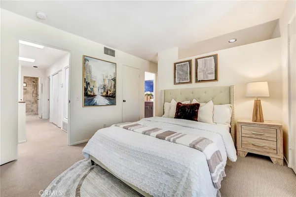 a bedroom with a bed and a painting on the wall