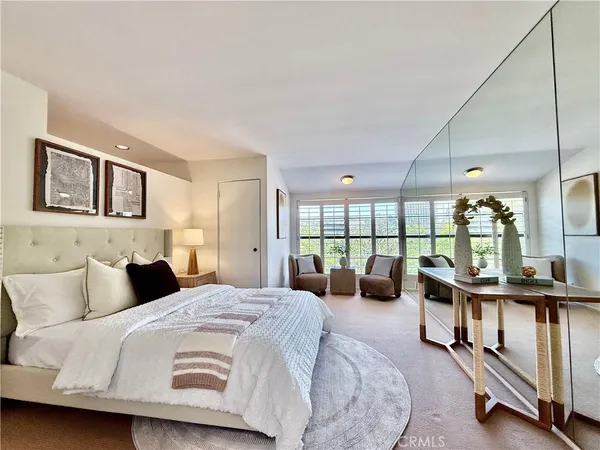 a bedroom with a bed a large window and couch