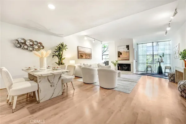 a living room with a couch and a dining table with wooden floor