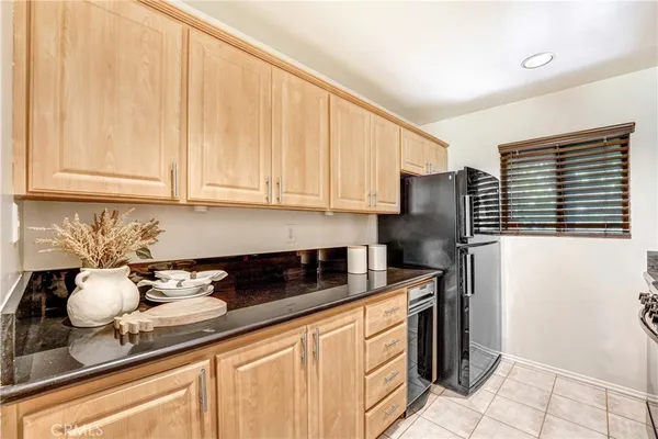 a kitchen with stainless steel appliances granite countertop a sink a stove a refrigerator and cabinets