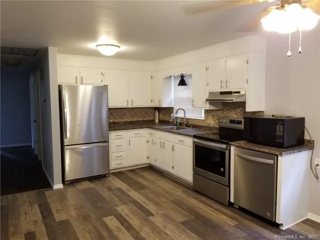a kitchen with a refrigerator stove and white cabinets