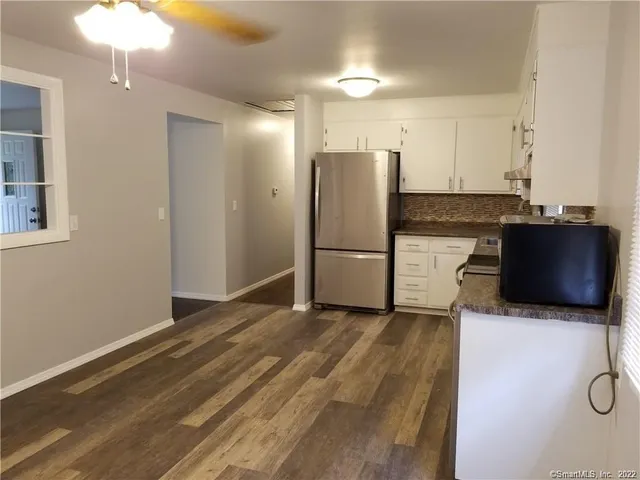 a kitchen with granite countertop a refrigerator and a stove top oven