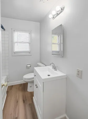 a bathroom with a sink a toilet and mirror