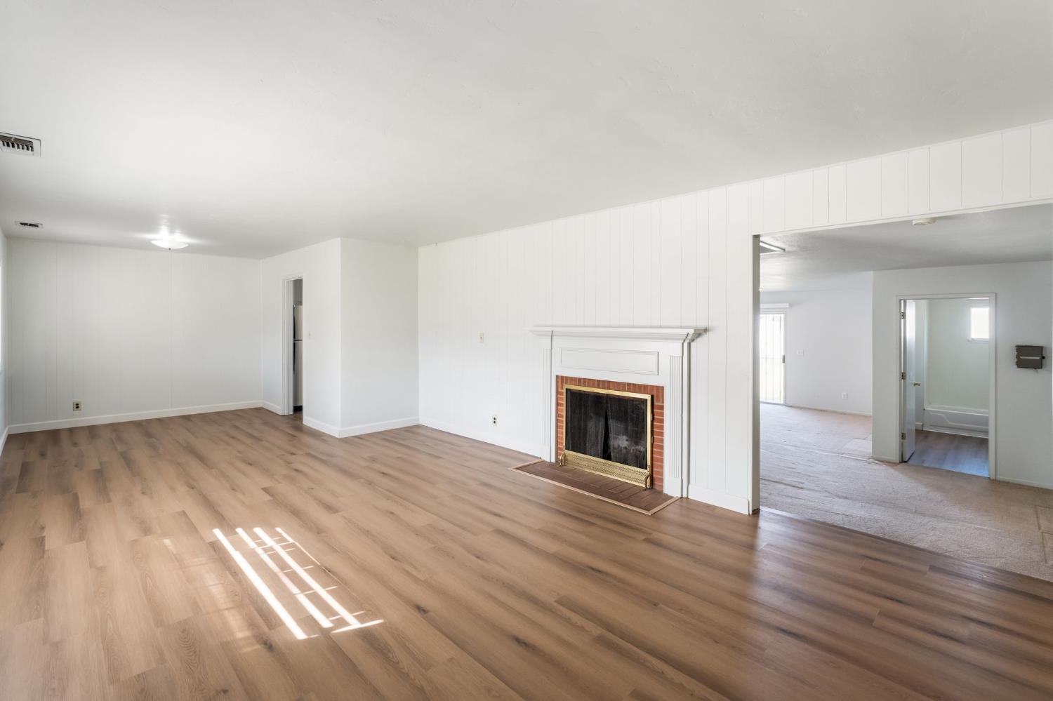 2315 Tyrolean Way Sacramento, CA 95821 - Photo 2 of 27 a view of empty room with wooden floor and fireplace