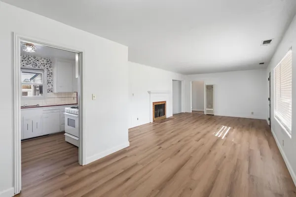 a view of a kitchen with wooden floor and a sink