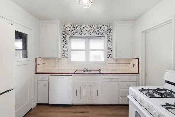 a kitchen with granite countertop a sink and cabinets