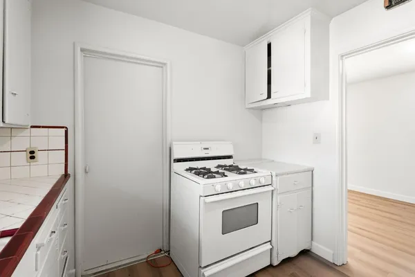 a kitchen with white cabinets and white appliances