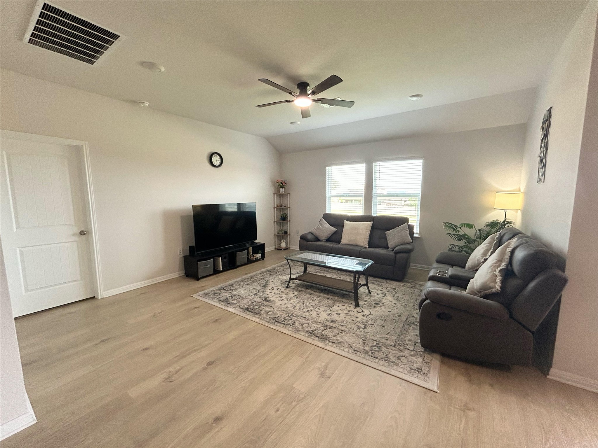 2412 Lightning View Leander, TX 78641 - Photo 4 of 24 A comfortable living area with light wood flooring and a refreshing ceiling fan.
