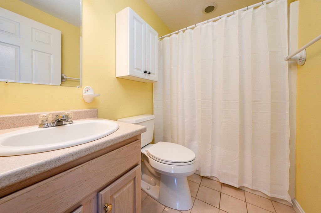9 Executive Drive, Unit 286 Mashpee, MA 02649 - Photo 15 of 15 a bathroom with a sink a toilet and shower curtain