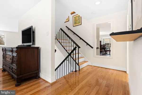 a view of a hallway with wooden floor and staircase