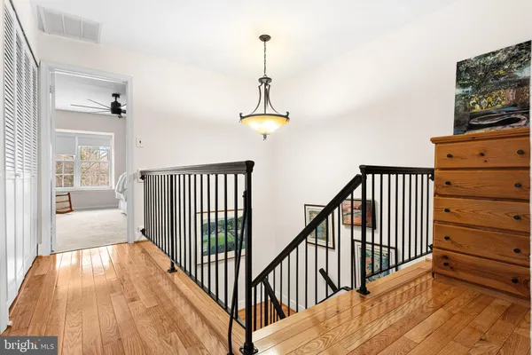 a view of a hallway with wooden floor and windows