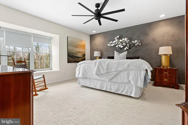 a bedroom with a large bed chandelier and a window