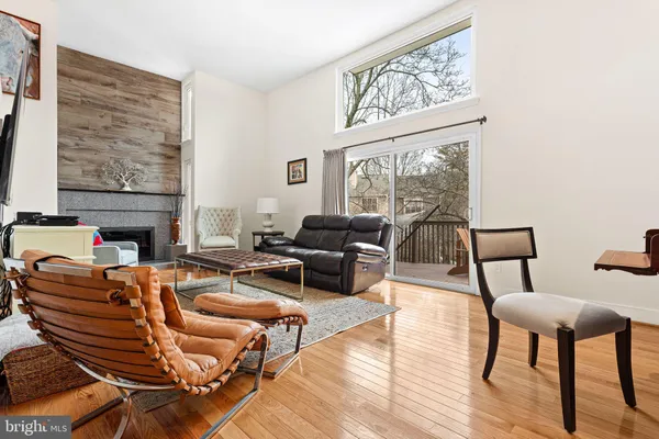 a living room with furniture a large window and wooden floor
