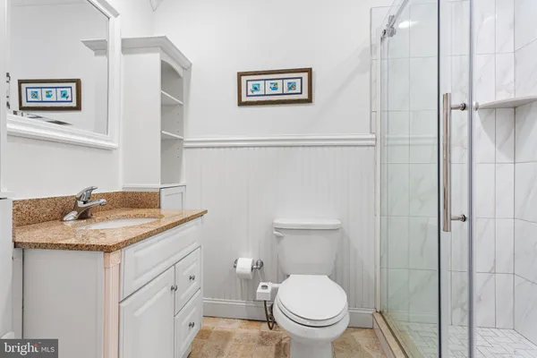 a bathroom with a granite countertop toilet sink and a mirror