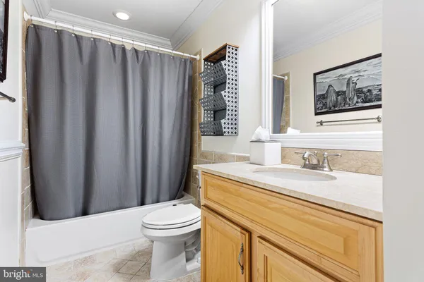 a bathroom with a granite countertop toilet sink and mirror