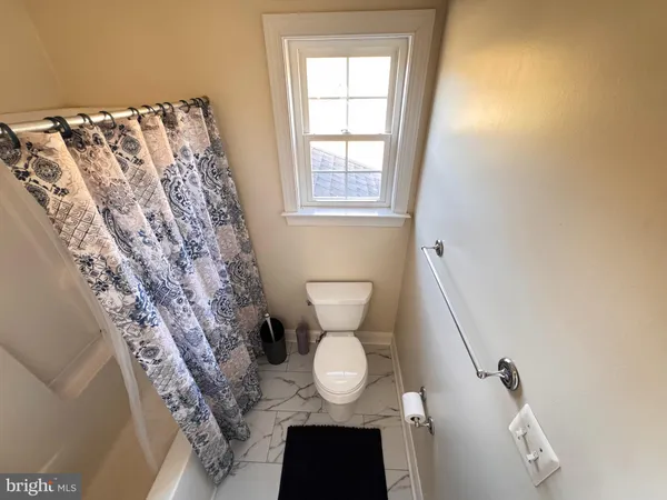 a bathroom with a toilet and a shower curtain