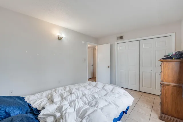 a bedroom with a bed and a refrigerator