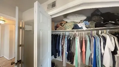 a view of walk in closet with clothes and shoes