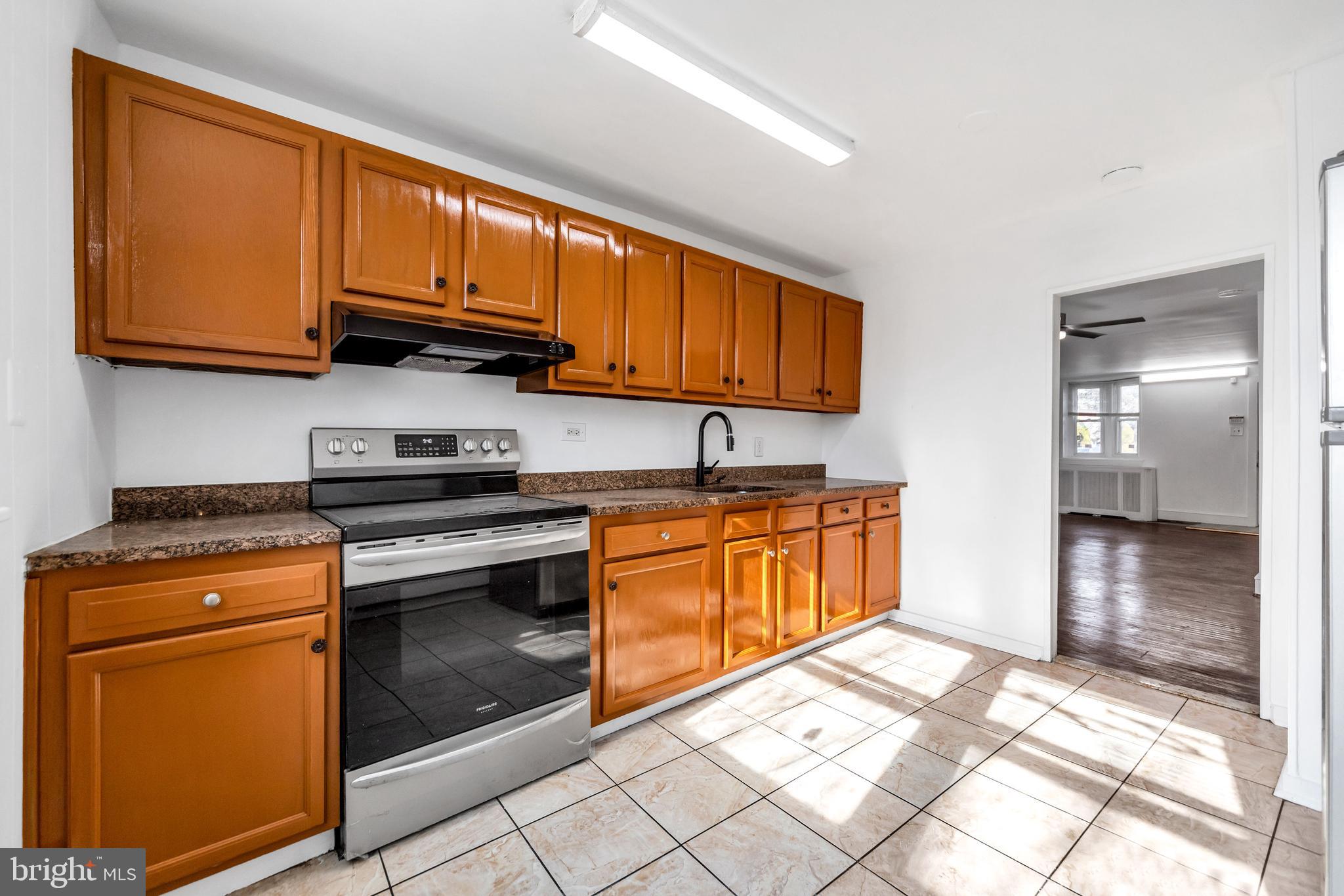 196 Springton Road Upper Darby, PA 19082 - Photo 11 of 27 a kitchen with stainless steel appliances granite countertop a stove a sink and a microwave