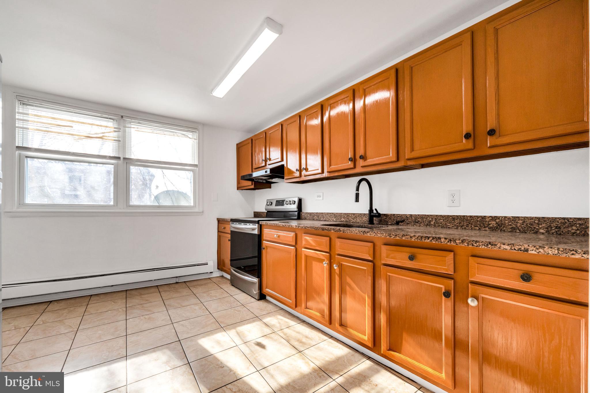196 Springton Road Upper Darby, PA 19082 - Photo 12 of 27 a kitchen with granite countertop a sink cabinets stainless steel appliances and a window